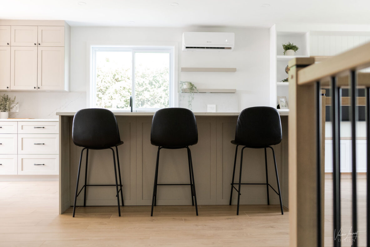A modern farmhouse kitchen island with black counterstools.
